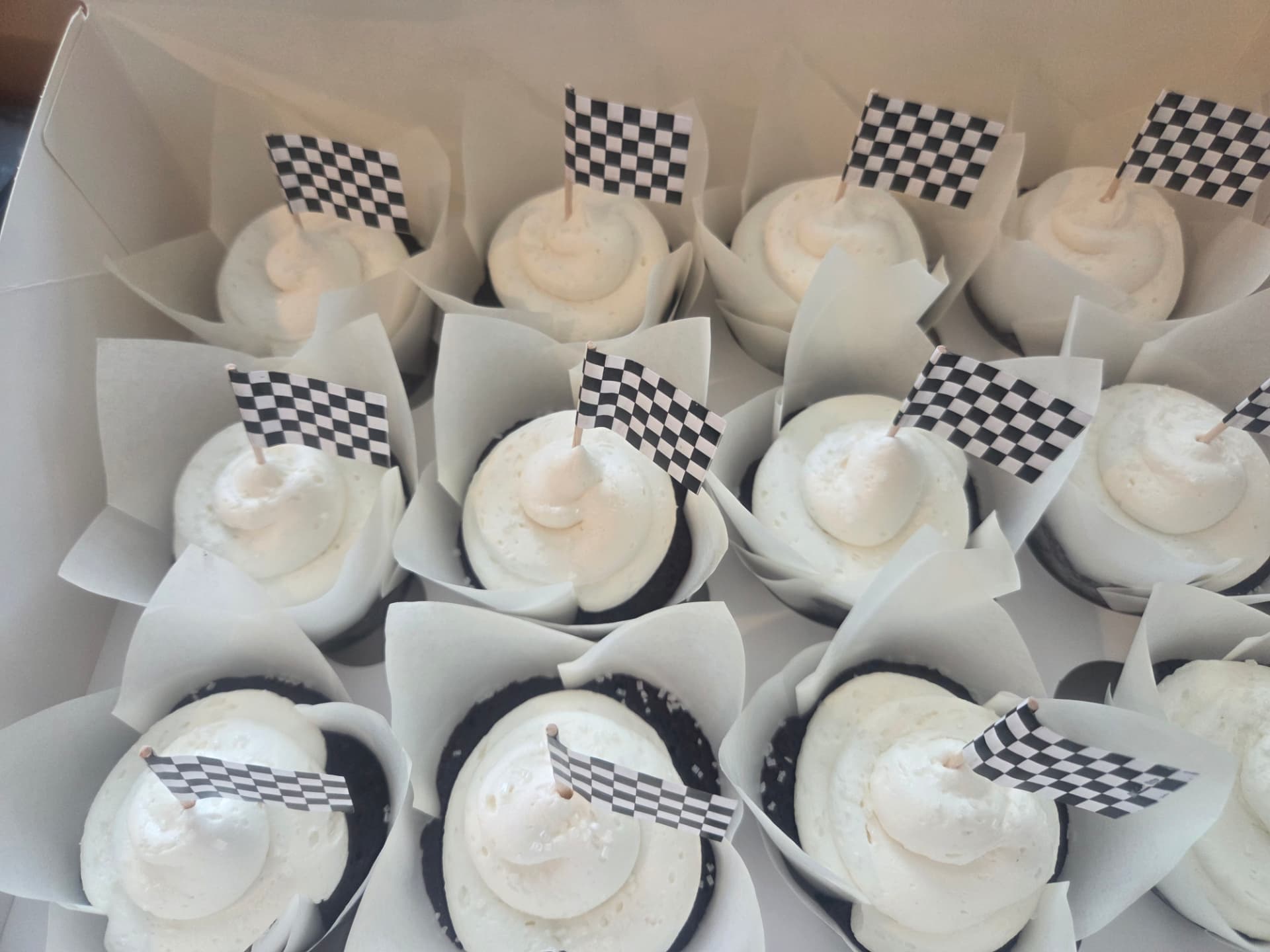 Chocolate cupcakes topped with checkered racing flags
